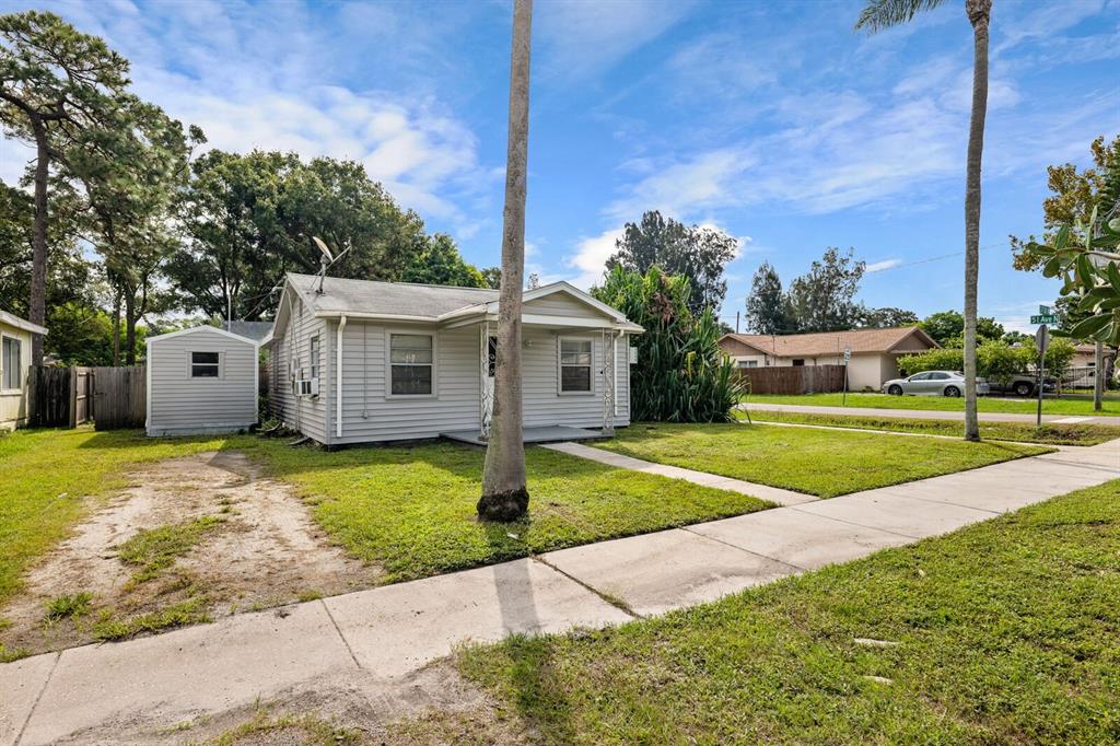 A single-story house with light gray siding, a small front porch, and a storage shed — 5101 37TH STREET N, ST PETERSBURG, FL