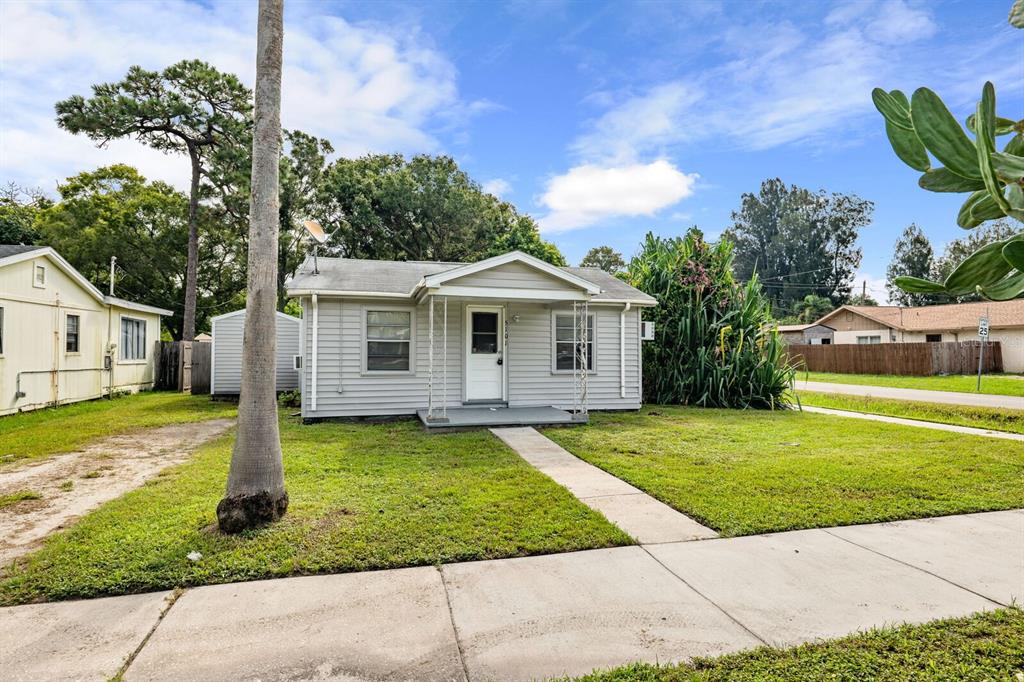A single-story gray house with a front porch and a concrete walkway sits on grass — 5101 37TH STREET N, ST PETERSBURG, FL