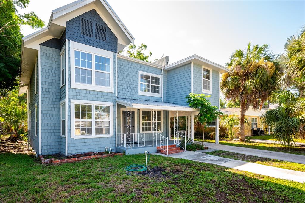 A two-story blue house with shingle siding and a front porch sits on a lawn — 309 BATH STREET, TARPON SPRINGS, FL