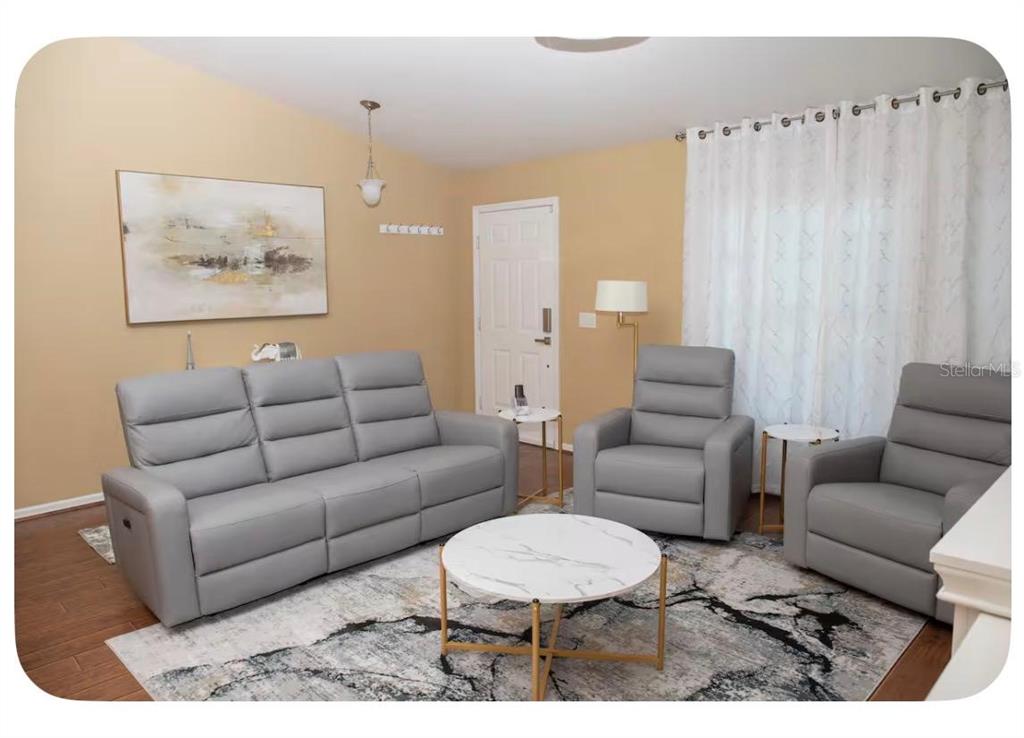 A living room features a grey sofa, two matching armchairs, and a round marble coffee table — 4568 THISBE STREET, NORTH PORT, FL