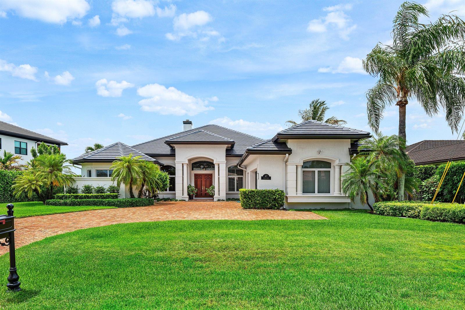A single-story house with a tiled roof, brick driveway, and palm trees in the front yard — 47 River Drive, Tequesta FL 33469, TEQUESTA, FL