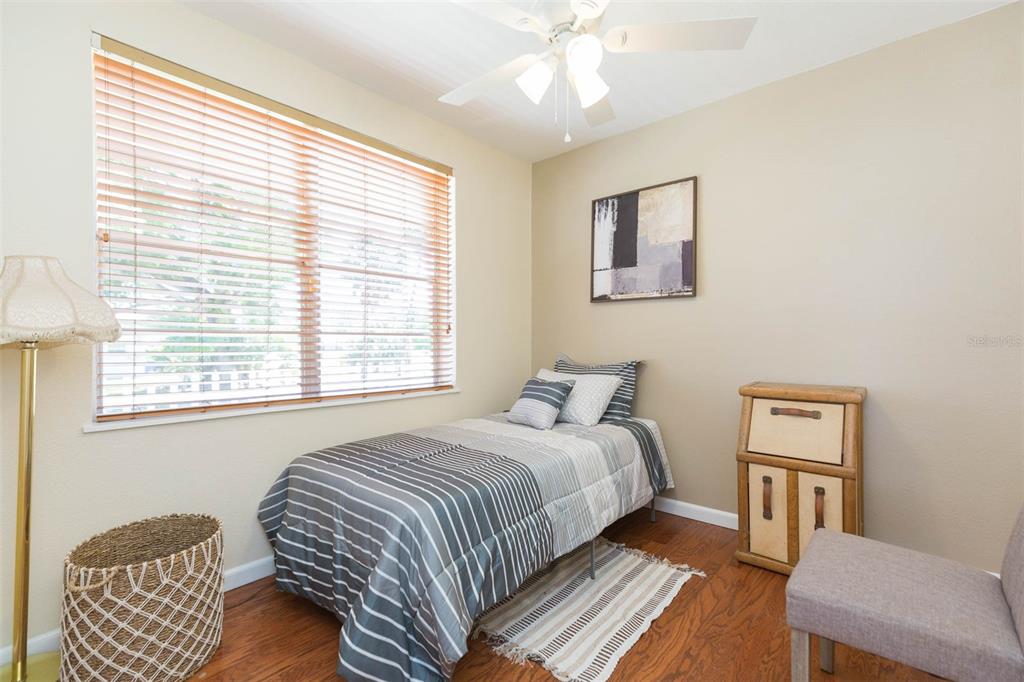 A bedroom features a single bed, wood flooring, a ceiling fan, and a window with blinds — 2504 E 12TH AVENUE, TAMPA, FL
