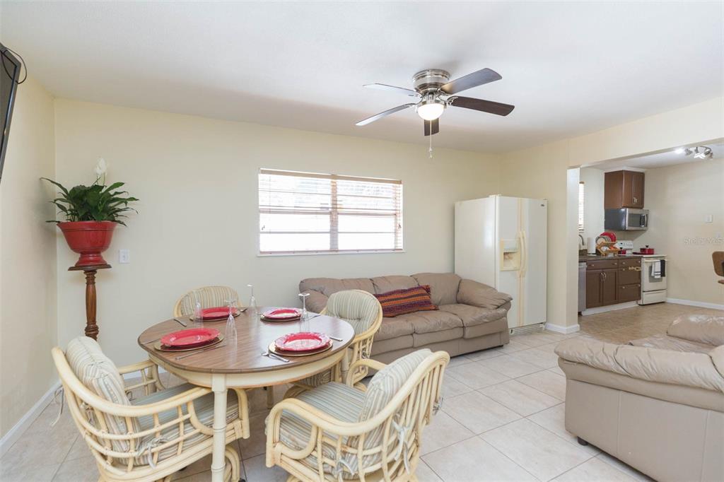A dining area with a round table and wicker chairs sits adjacent to a living room — 2504 E 12TH AVENUE, TAMPA, FL