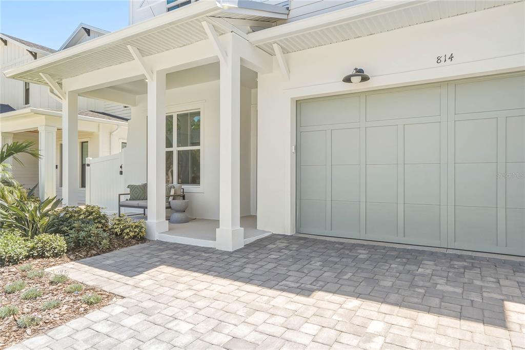 A paved driveway leads to a white house with a light green garage door — 814 W AMELIA AVENUE, TAMPA, FL