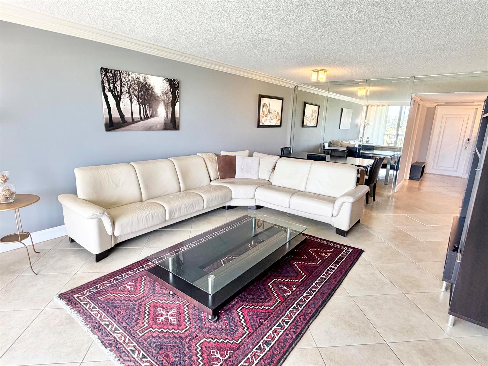 A living room features a white sectional sofa, a glass coffee table, and a patterned rug — 3001 S Palm Aire Drive # 206, Pompano Beach FL 33069, POMPANO BEACH, FL