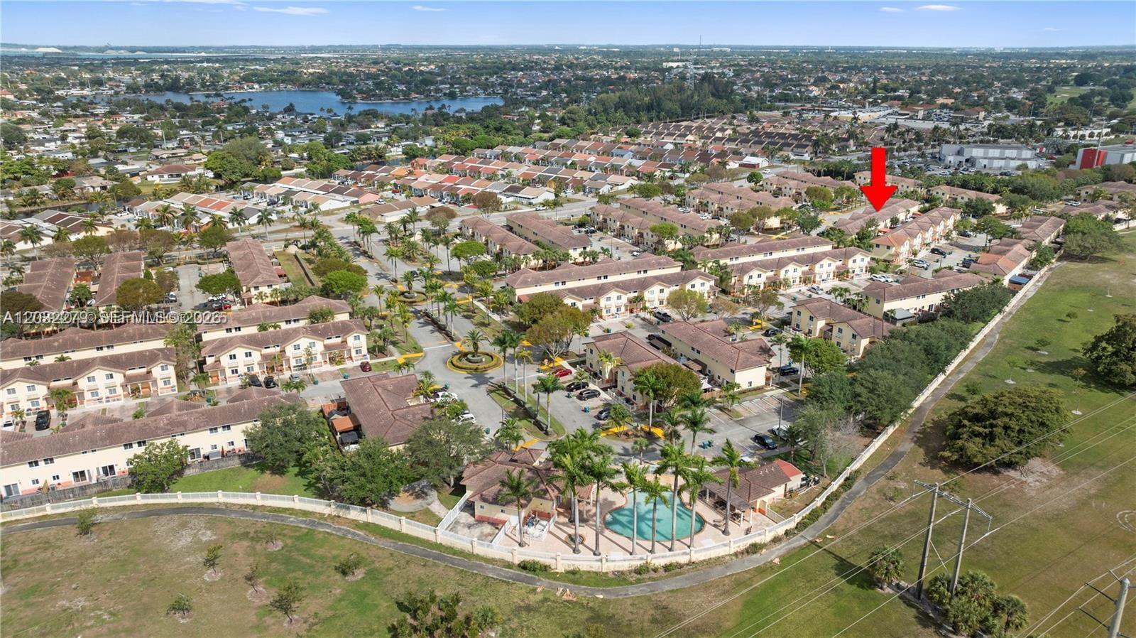 An aerial view shows a residential townhouse complex with a swimming pool and parking lots — 17866 NW 74th Ct, Hialeah FL 33015, HIALEAH, FL
