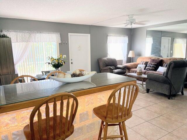 A kitchen island with a glass top and glass block base faces a living room — 5839 La Pinata Boulevard, FL 33463, FL