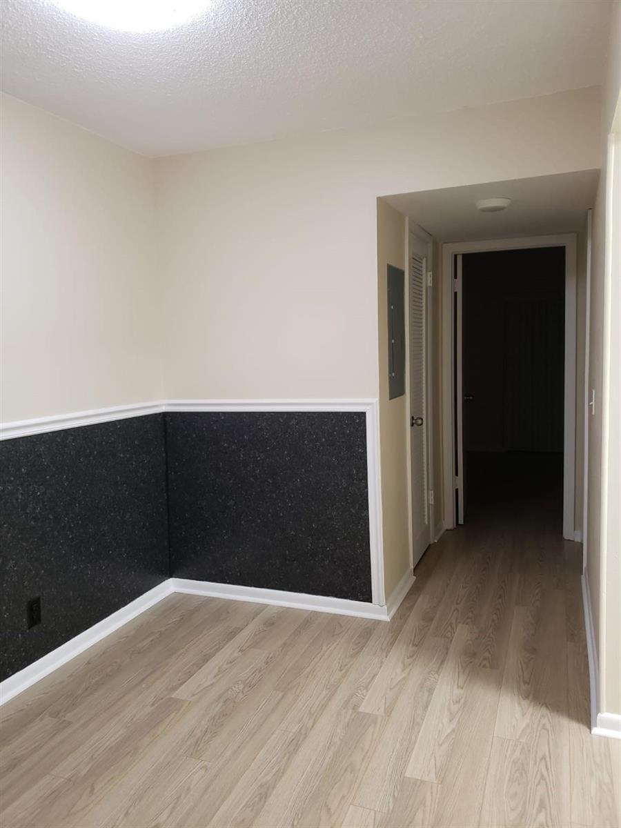 A room with light wood flooring, beige walls, and a dark speckled wainscoting panel — 146 Canterbury # 146, West Palm Beach FL 33417, WEST PALM BEACH, FL