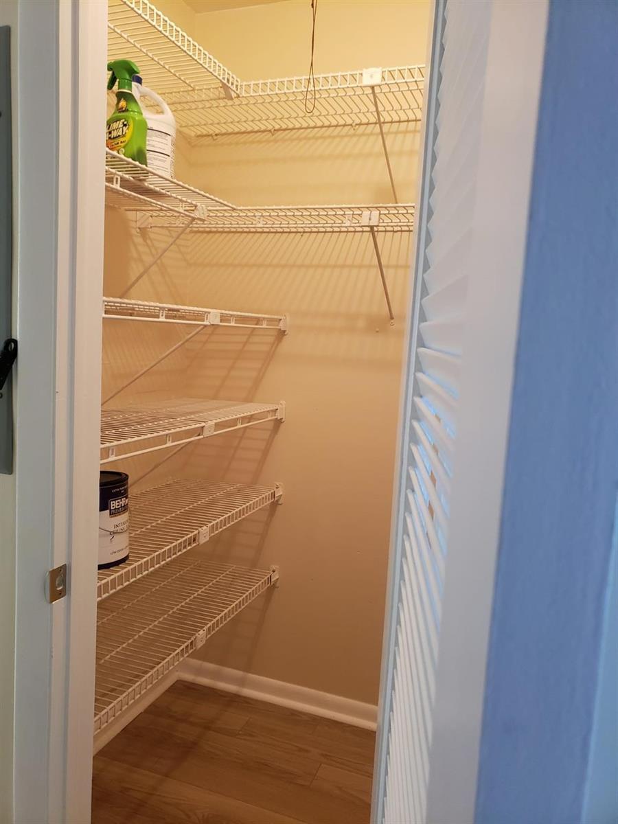 A small walk-in closet features white wire shelving and light-colored wood-look flooring — 146 Canterbury # 146, West Palm Beach FL 33417, WEST PALM BEACH, FL