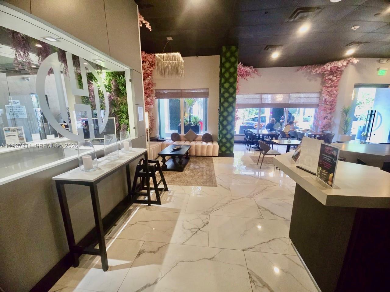 A modern restaurant interior features marble floors, floral decor, and a lounge seating area — 185 SE 14th Ter # 2701, Miami FL 33131, MIAMI, FL