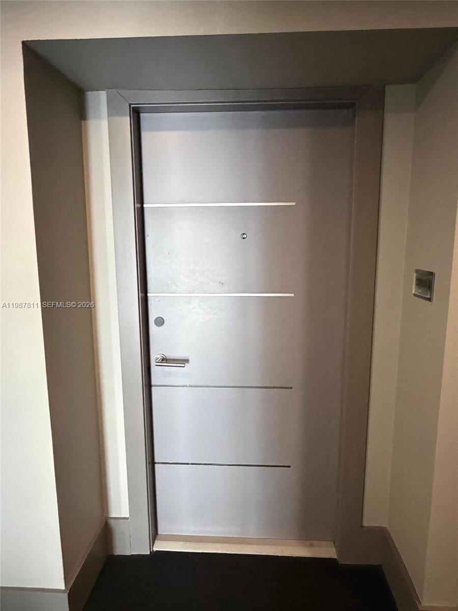 A gray interior door features horizontal silver accents, a handle, and a peephole — 185 SE 14th Ter # 2701, Miami FL 33131, MIAMI, FL