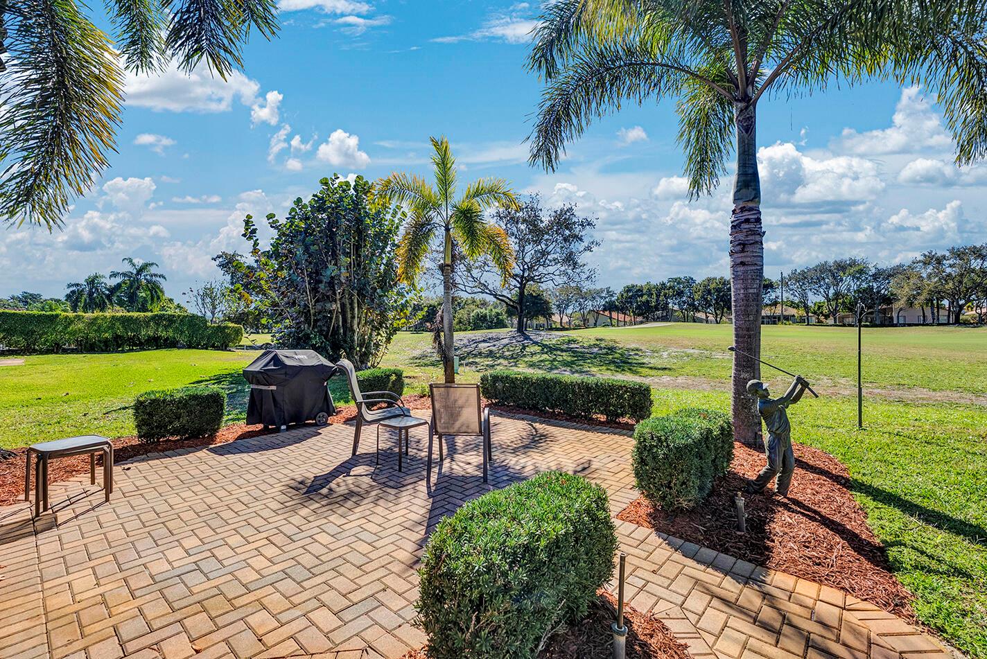 A brick patio features a grill, outdoor chairs, and a golf statue overlooking a course — 5362 Piping Rock Drive, Boynton Beach FL 33437, BOYNTON BEACH, FL