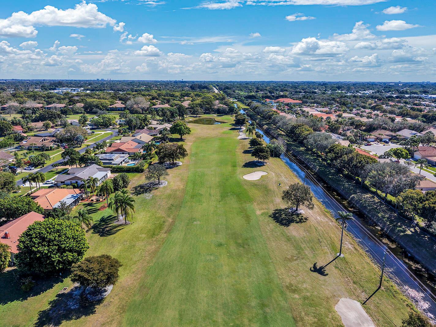 An aerial view shows a golf course fairway bordered by residential houses and a canal — 5362 Piping Rock Drive, Boynton Beach FL 33437, BOYNTON BEACH, FL