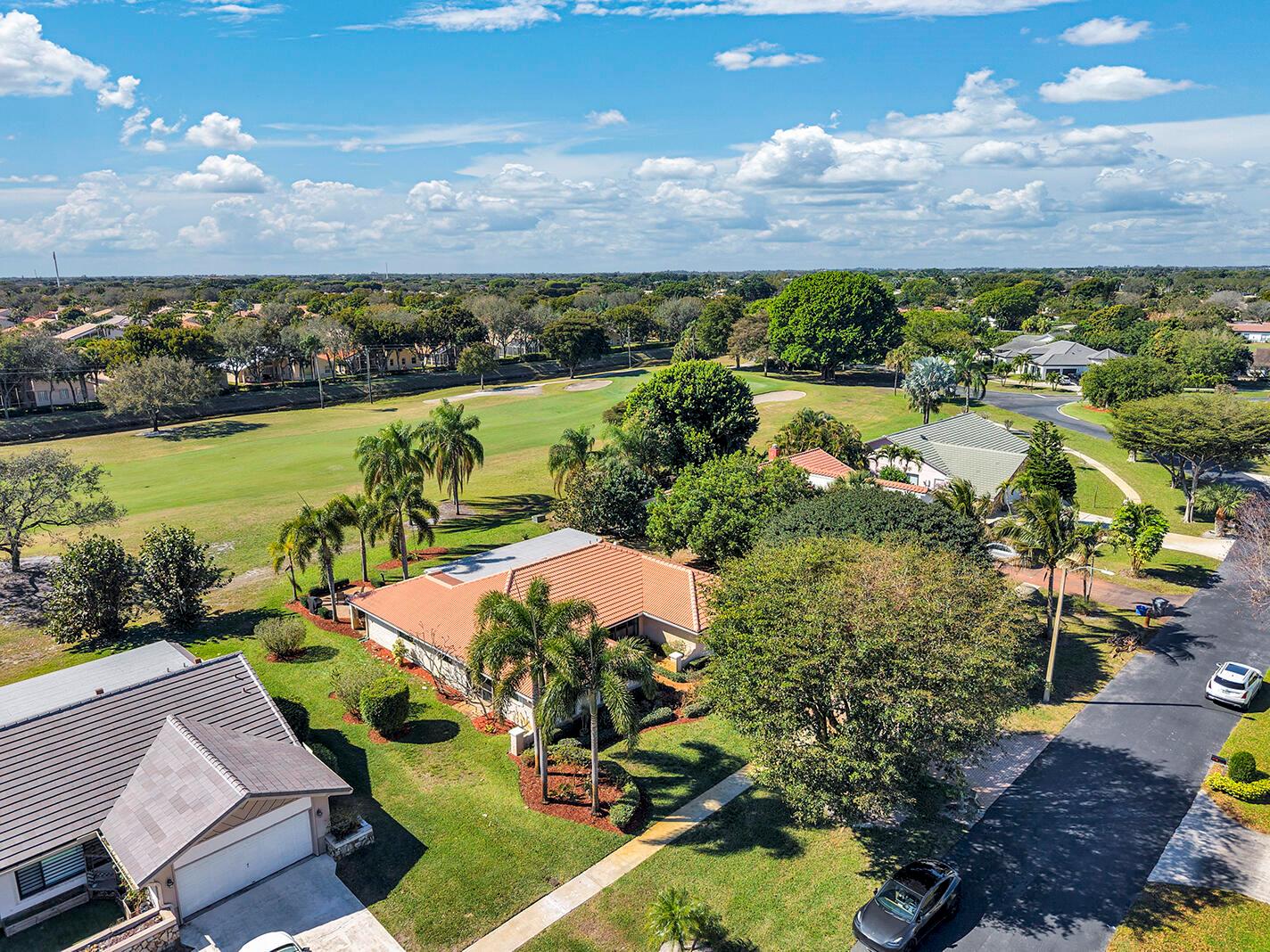 An aerial view shows suburban houses with tiled roofs situated along a green golf course — 5362 Piping Rock Drive, Boynton Beach FL 33437, BOYNTON BEACH, FL