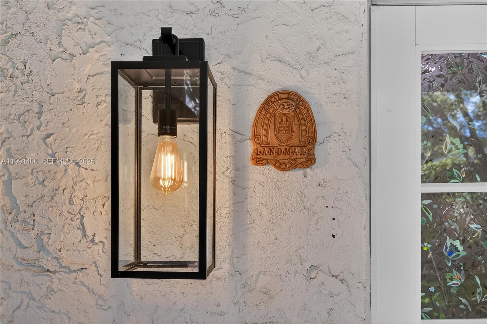 A black rectangular outdoor light fixture hangs next to a Coral Gables landmark plaque — 1109 Almeria Ave, Coral Gables FL 33134, CORAL GABLES, FL