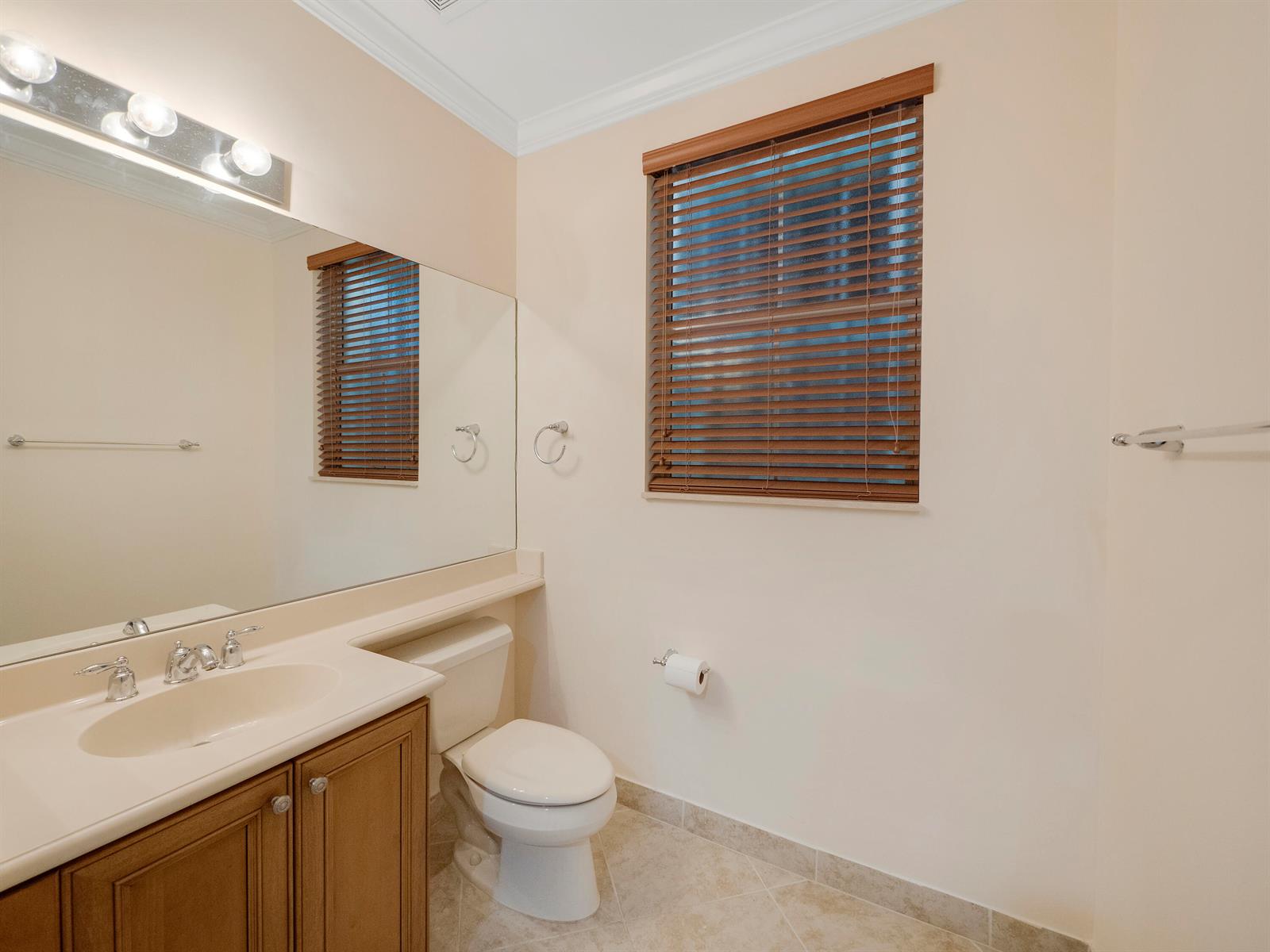 A bathroom features a vanity with a sink, a toilet, and a window with blinds — 1859 Vía Granada, Boynton Beach FL 33426, BOYNTON BEACH, FL