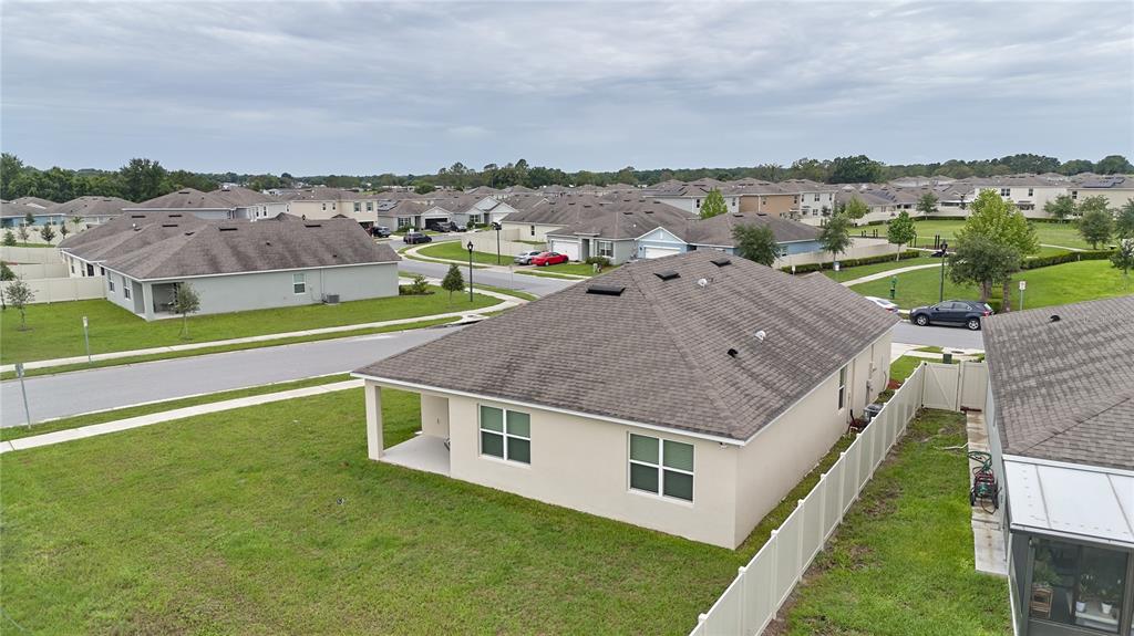An aerial view shows a suburban neighborhood with single-family homes, paved streets, and green lawns — 1679 AURORA RIDGE DRIVE, ZELLWOOD, FL