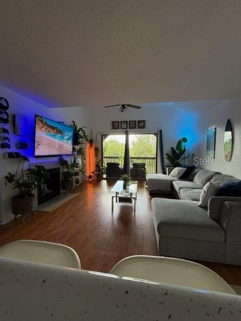 A living room features wood flooring, a large sectional sofa, and a wall-mounted television — 355 LAKEPOINTE DRIVE UNIT 304, ALTAMONTE SPRINGS, FL