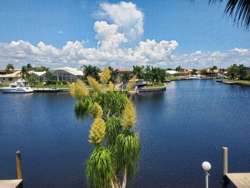A view of a canal with boats and houses from behind a screened-in porch — 3768 BAL HARBOR BOULEVARD UNIT 4, PUNTA GORDA, FL