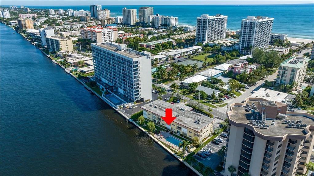An aerial view shows a low-rise apartment building with a pool along a waterway — 505 N Riverside Drive # 4, Pompano Beach FL 33062, POMPANO BEACH, FL