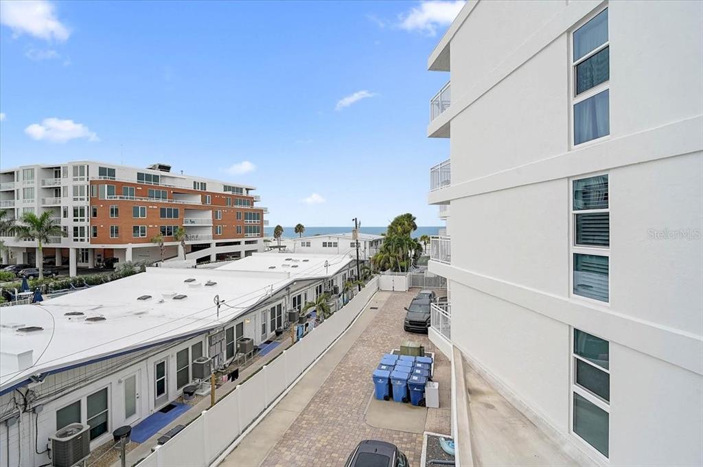 An elevated view shows a paved alleyway between a white building and a low-rise complex — 6518 MIDNIGHT PASS ROAD UNIT 309, SIESTA KEY, FL