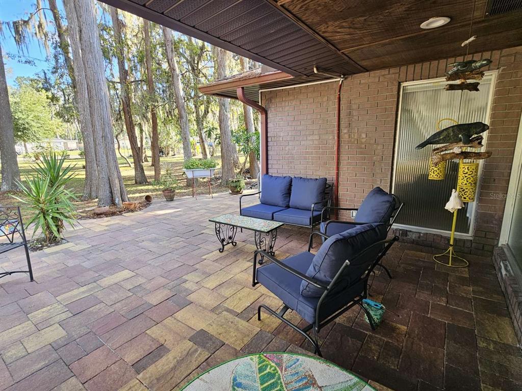 A tiled entryway features a rug, a shelving unit, and a large frosted glass wall — 5757 SWEET CHERRY LANE, LAND O LAKES, FL