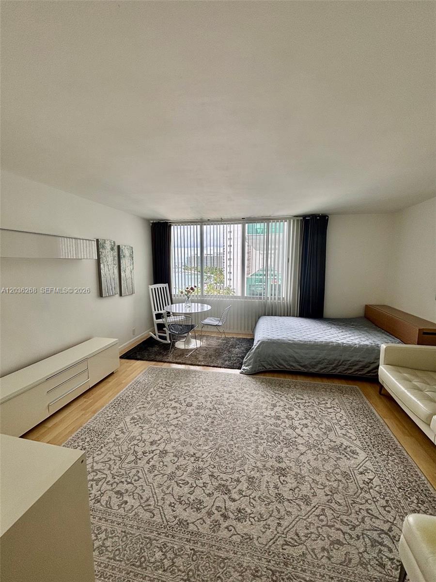A studio apartment features a bed, a dining set, and a large patterned area rug — 1000 West Ave # 822, Miami Beach FL 33139, MIAMI BEACH, FL