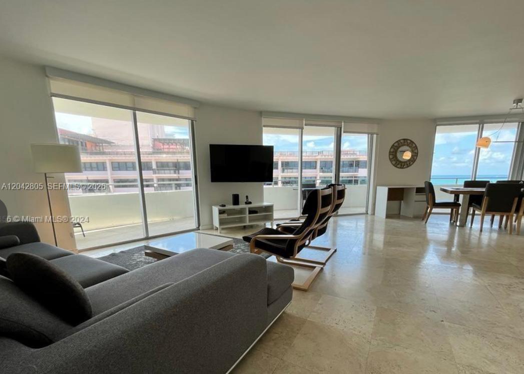 A living and dining area features tile floors, floor-to-ceiling windows, and a balcony view — 5161 E Collins Ave # 1612, Miami Beach FL 33140, MIAMI BEACH, FL