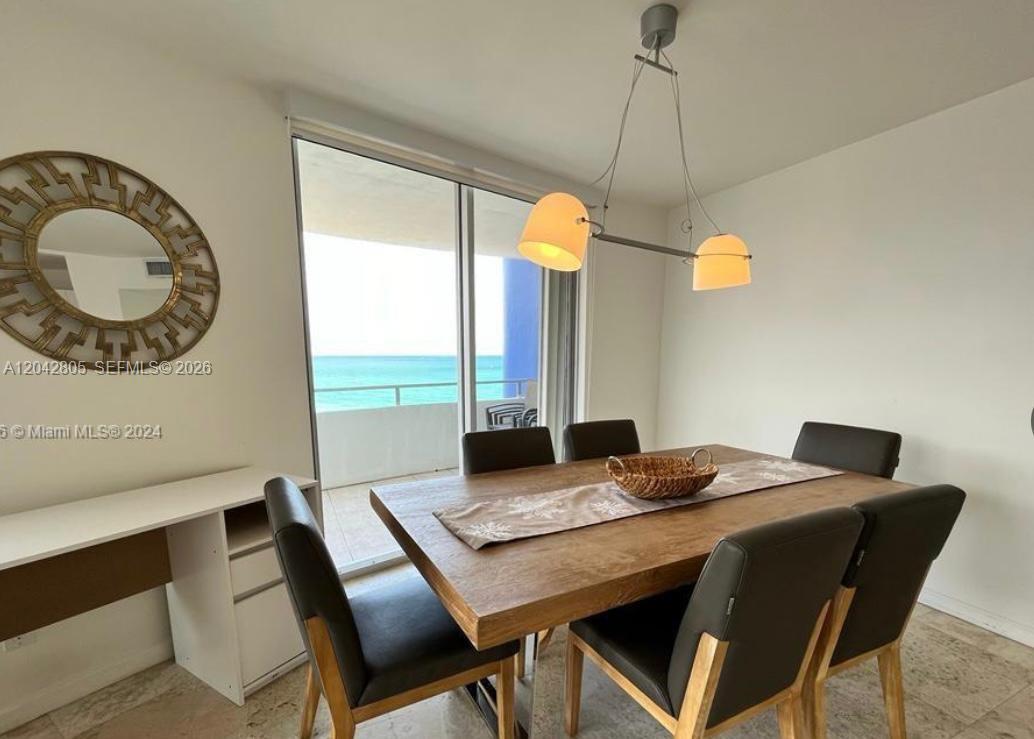 A dining room features a wooden table, six chairs, a pendant light, and ocean views — 5161 E Collins Ave # 1612, Miami Beach FL 33140, MIAMI BEACH, FL