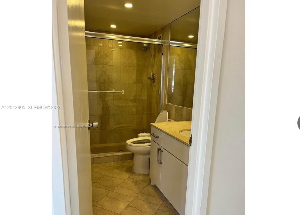 A bathroom features a glass-enclosed shower, a white vanity, and light-colored tile flooring — 5161 E Collins Ave # 1612, Miami Beach FL 33140, MIAMI BEACH, FL
