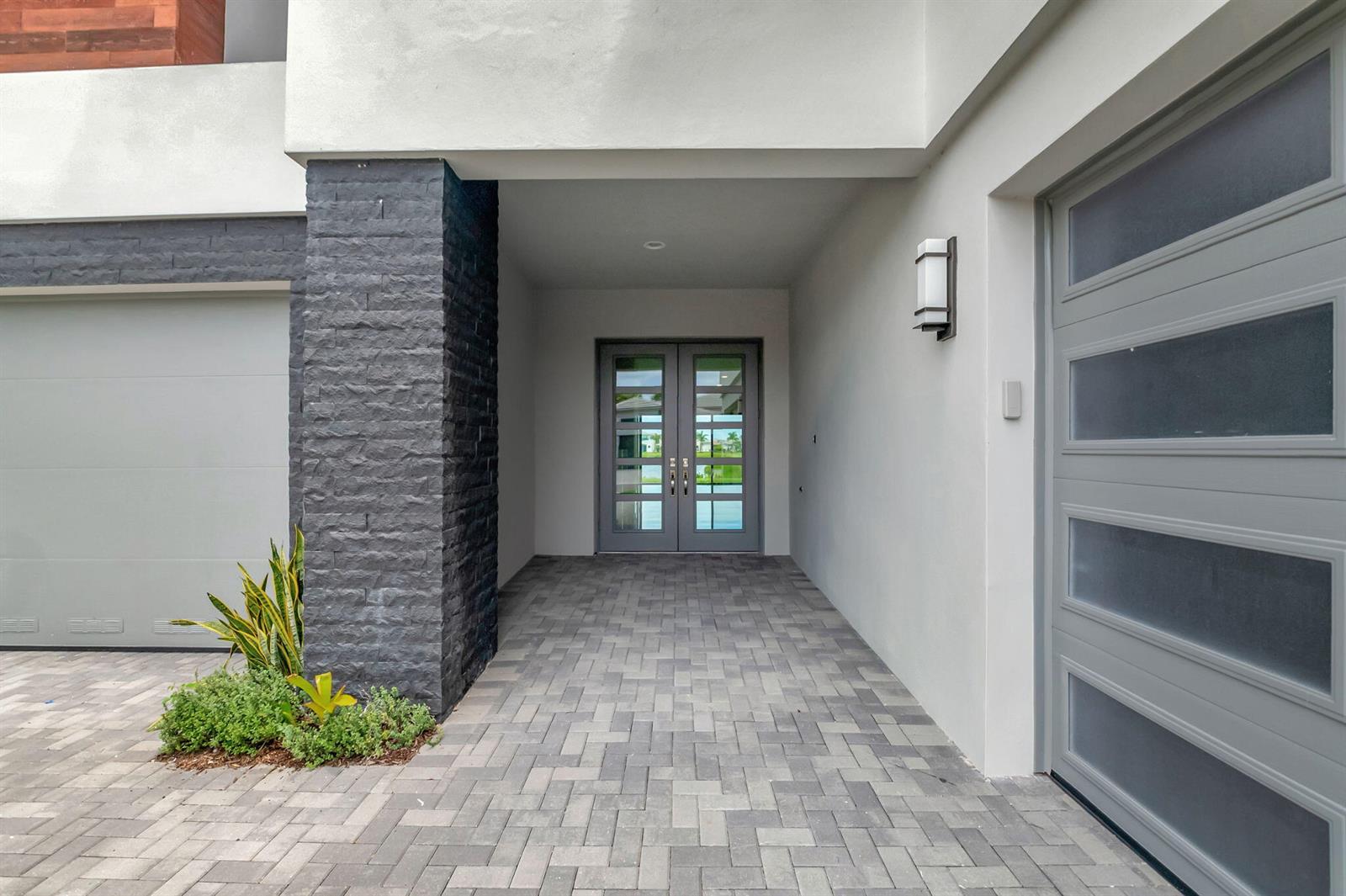 A paved entryway leads to double glass doors flanked by a dark stone pillar — 20146 Casa De Campo Lane, Boca Raton FL 33434, BOCA RATON, FL