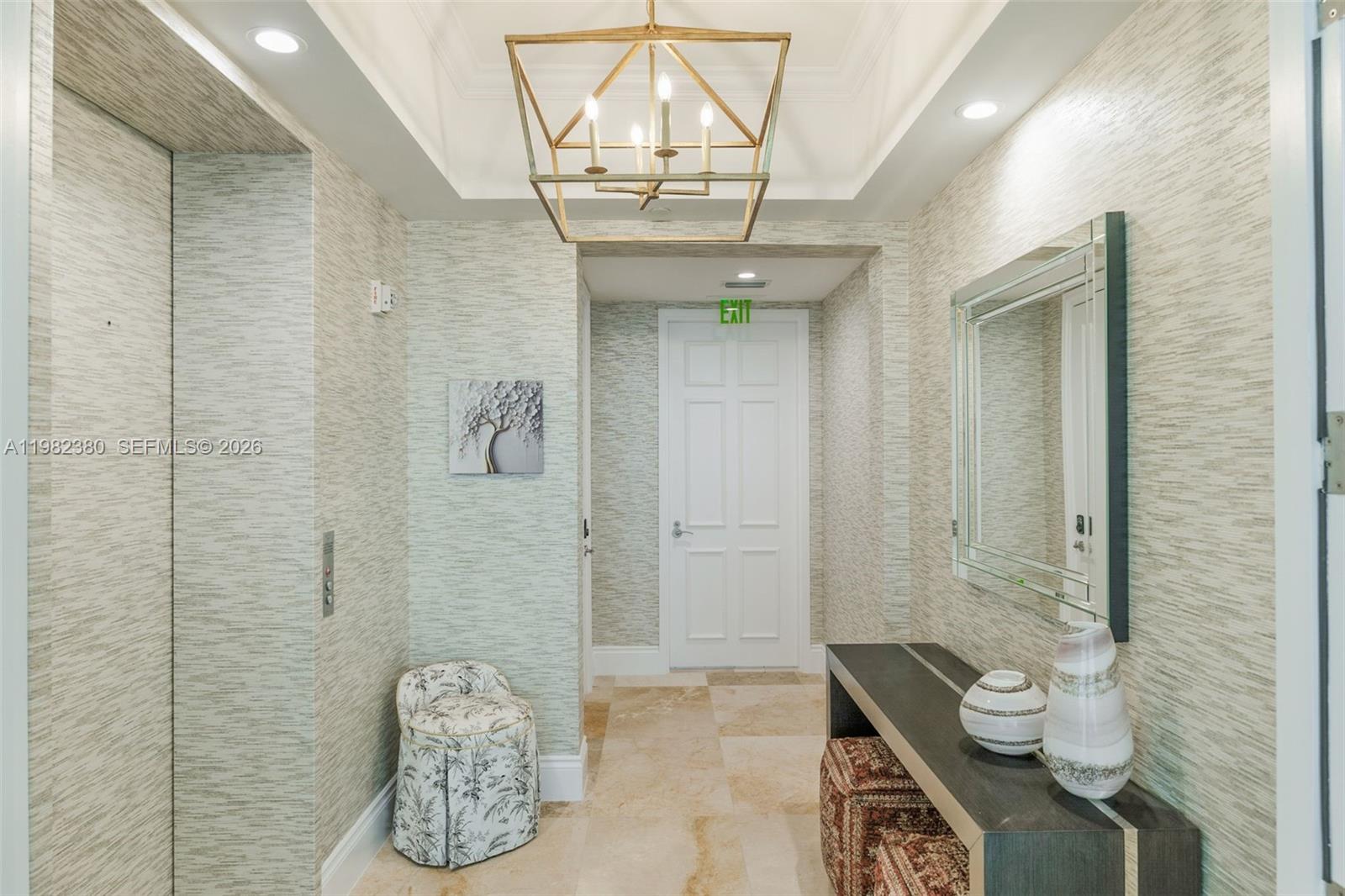 A foyer features textured wallpaper, a geometric chandelier, a console table, and a white door — 10295 Collins Ave # 2203, Bal Harbour FL 33154, BAL HARBOUR, FL