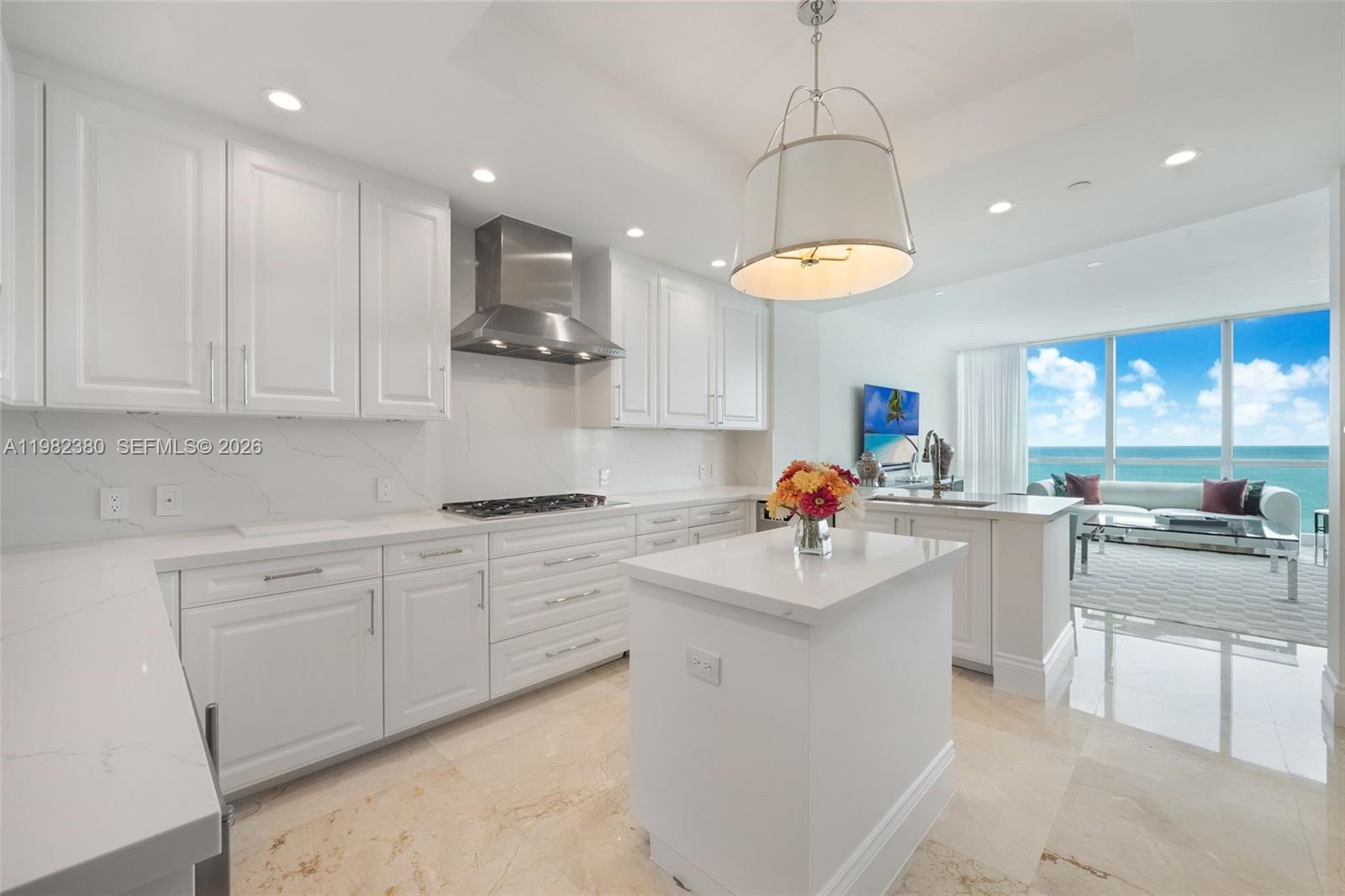 A modern white kitchen features marble countertops, stainless steel appliances, and an ocean view — 10295 Collins Ave # 2203, Bal Harbour FL 33154, BAL HARBOUR, FL