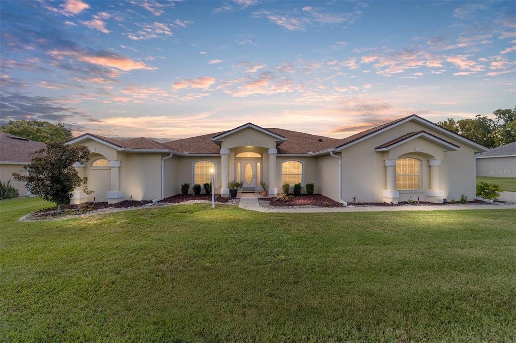 A single-story suburban house with a beige stucco exterior and a brown shingled roof — 3465 SE 54TH AVENUE, OCALA, FL