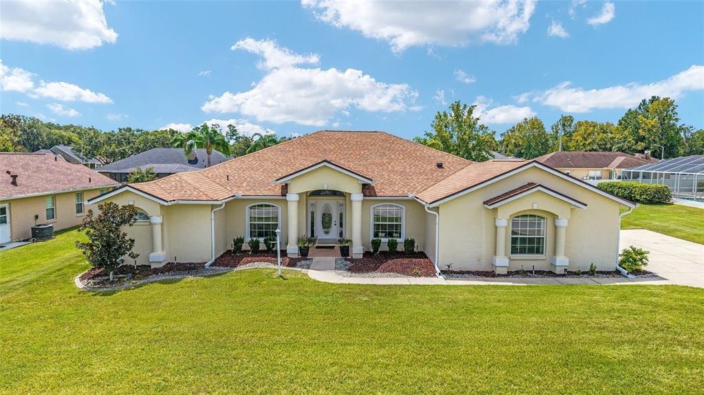 A single-story, light-yellow stucco house with a brown shingled roof and a front porch — 3465 SE 54TH AVENUE, OCALA, FL
