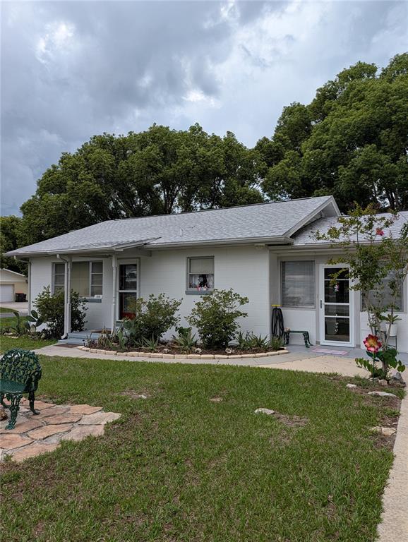 A single-story white house with a gray shingled roof and a front lawn — 11240 SE 53RD COURT, BELLEVIEW, FL