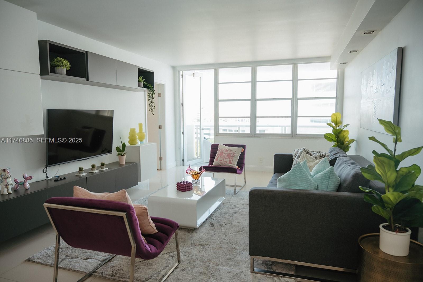 A modern living room features a gray sofa, two purple chairs, and a white coffee table — 3725 S Ocean Dr # 1019, Hollywood FL 33019, HOLLYWOOD, FL