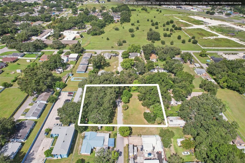 An aerial view shows a rectangular, partially wooded vacant lot outlined in white — 757 LAKE JESSIE DRIVE, WINTER HAVEN, FL