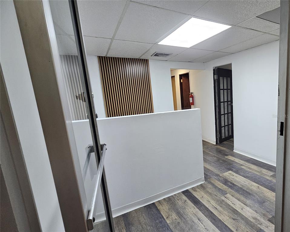 An office interior features a half-wall, wood-slat accent wall, wood-look flooring, and a glass door — 167 Plaza Pradera AVE ANTONIO PRINCIPE UNIT 2A, BAYAMON, PR
