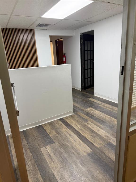 An office interior features wood-look vinyl flooring, a partial wall, and a dark-framed glass door — 167 Plaza Pradera AVE ANTONIO PRINCIPE UNIT 2A, BAYAMON, PR