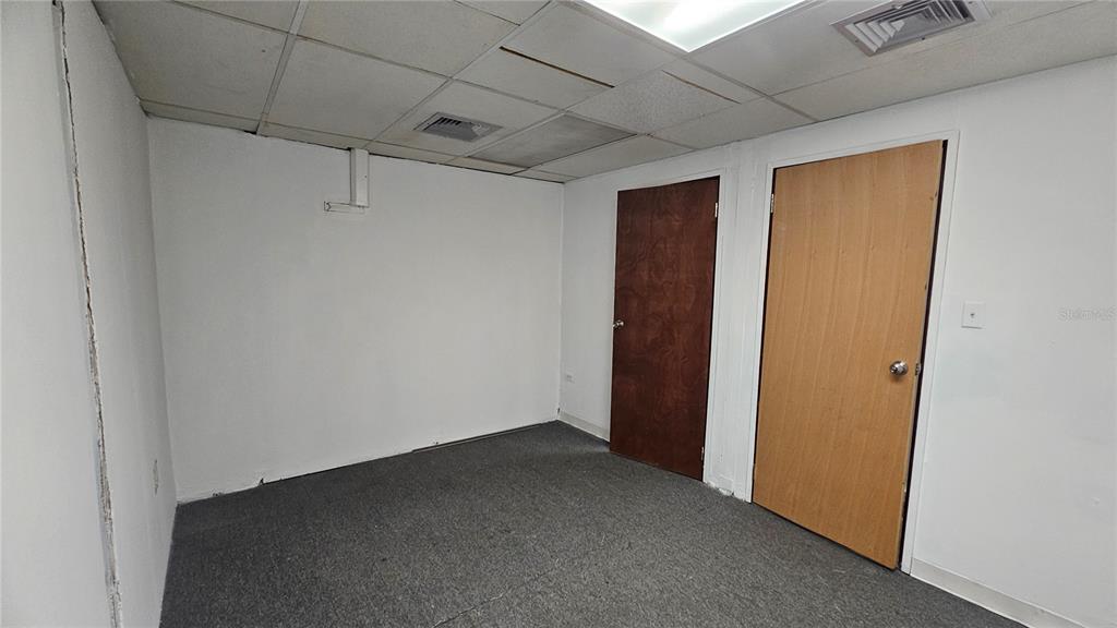 An empty room with gray carpet, white walls, a drop ceiling, and two wooden doors — 167 Plaza Pradera AVE ANTONIO PRINCIPE UNIT 2A, BAYAMON, PR