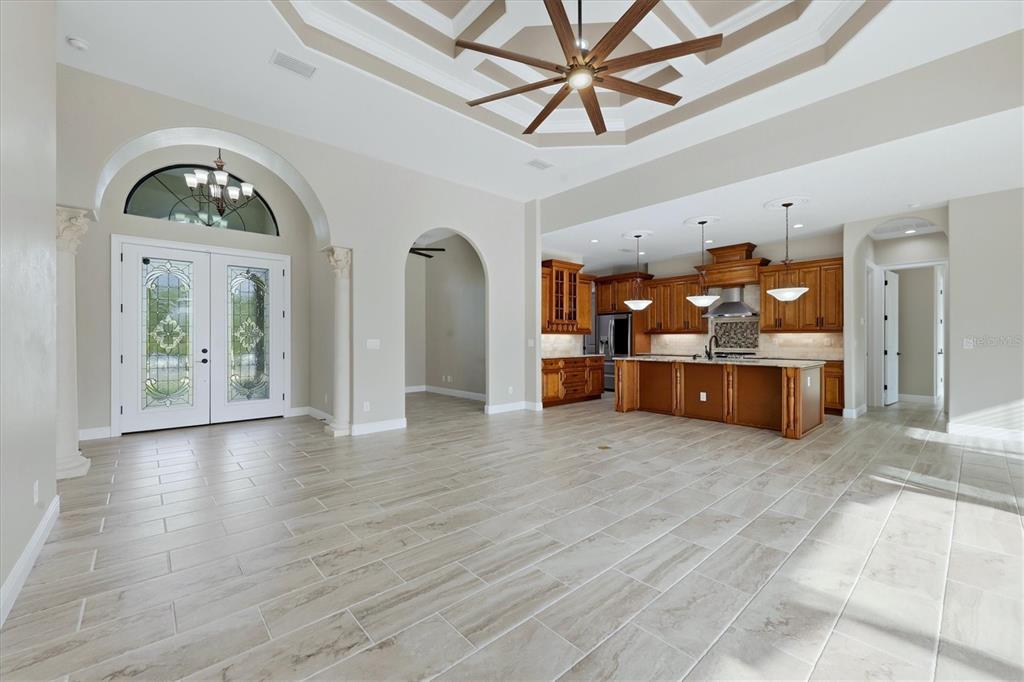 An open-concept living area features a coffered ceiling, tile flooring, and a wooden kitchen — 14654 SAN DOMINGO BOULEVARD, PORT CHARLOTTE, FL