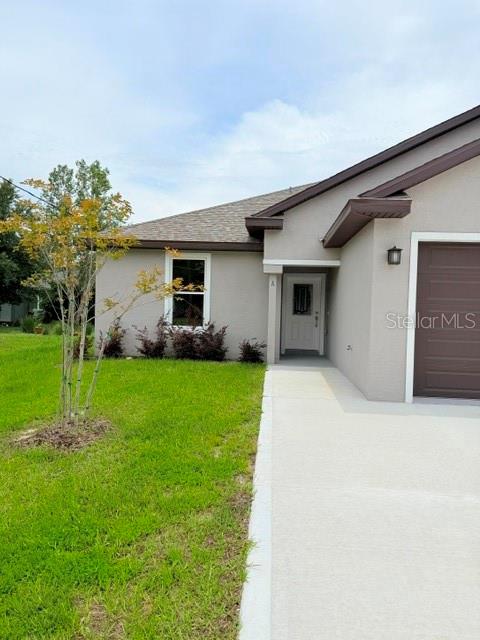 The exterior of a single-story house features a concrete driveway, a brown garage door, and landscaping — 16 SLUMBERLAND PATH UNIT B, PALM COAST, FL