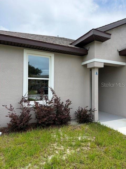 The exterior of a tan house features a window and a covered entryway labeled A — 16 SLUMBERLAND PATH UNIT B, PALM COAST, FL