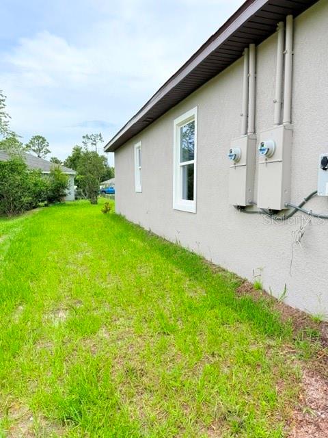The exterior side wall of a house features two electrical meters and a window — 16 SLUMBERLAND PATH UNIT B, PALM COAST, FL
