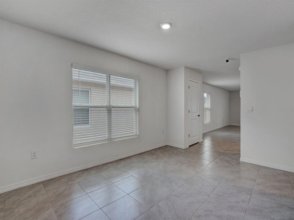 An empty room with white walls, tile flooring, a window with blinds, and a closet — 5586 LOGAN CAVE AVENUE, WIMAUMA, FL