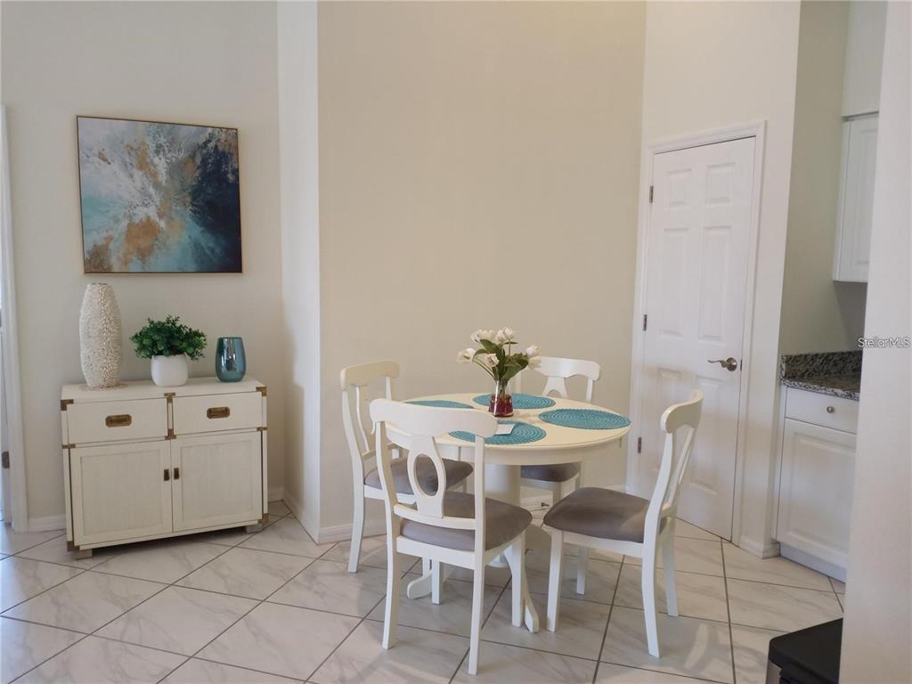 A dining area features a round white table with four chairs and a matching sideboard — 4216 CENTRAL SARASOTA PARKWAY UNIT 1325, SARASOTA, FL