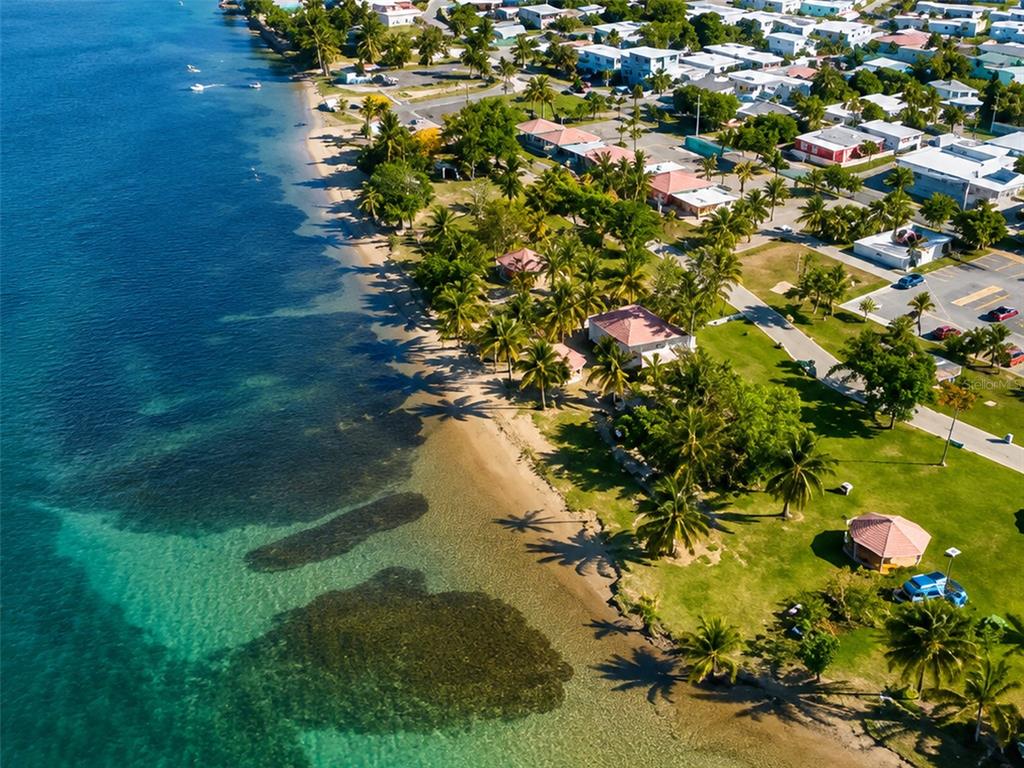 An aerial view shows a sandy beach with palm trees and houses along the coast — Carr #3 SOLIMAR PATILLAS, PATILLAS, PR