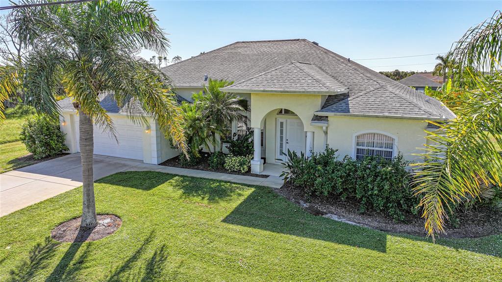 A single-story house with a white stucco exterior, a tiled roof, and a palm tree — 1185 ROTONDA CIRCLE, ROTONDA WEST, FL
