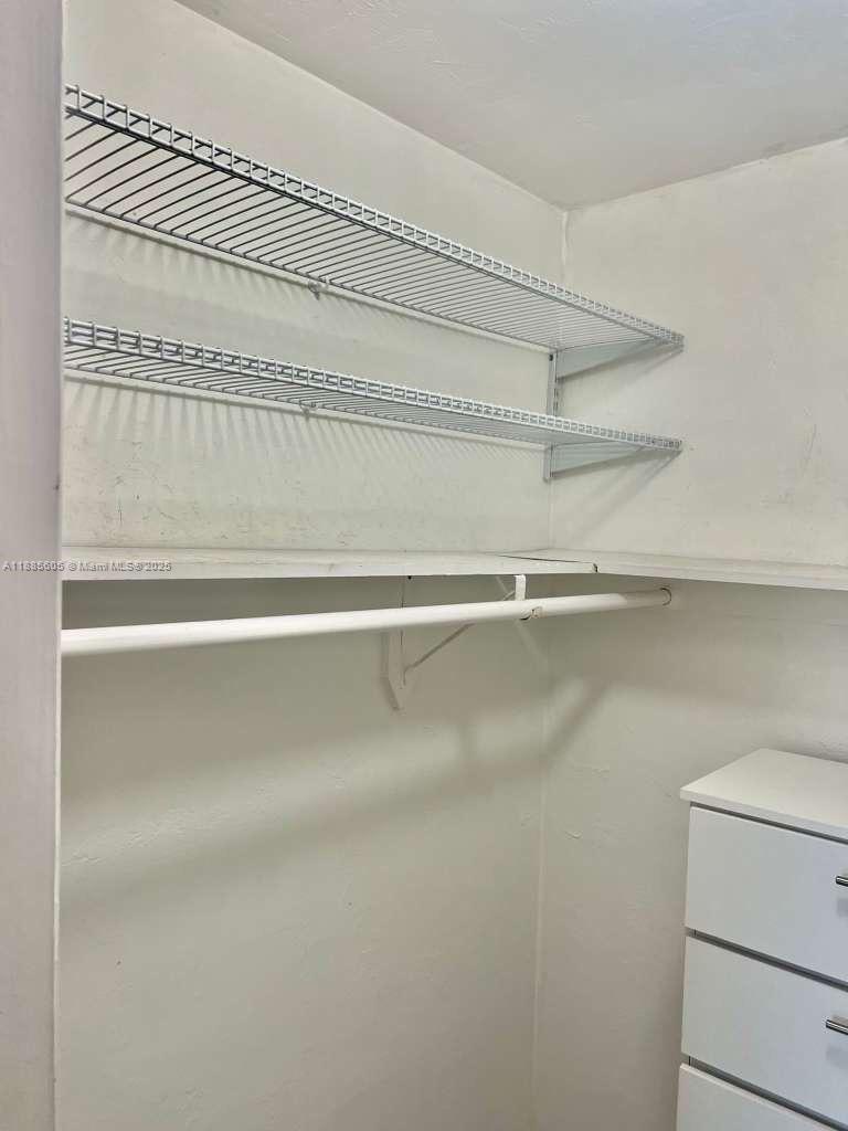 A closet features two wire shelves, a hanging rod, and a white dresser — 1300 W 53rd St # 18, Hialeah FL 33012, HIALEAH, FL